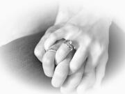 Mãos de noivos entrelaçadas a mostrar as alianças de casamento - Isilda Murteira Fotografia